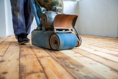male applying wood care products and cleaners on hardwood floor surface