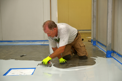 man applying epoxy product to floor