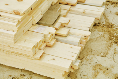 Stacks of pine, cedar, oak and other planks of uncut wood on the site of a new home construction site